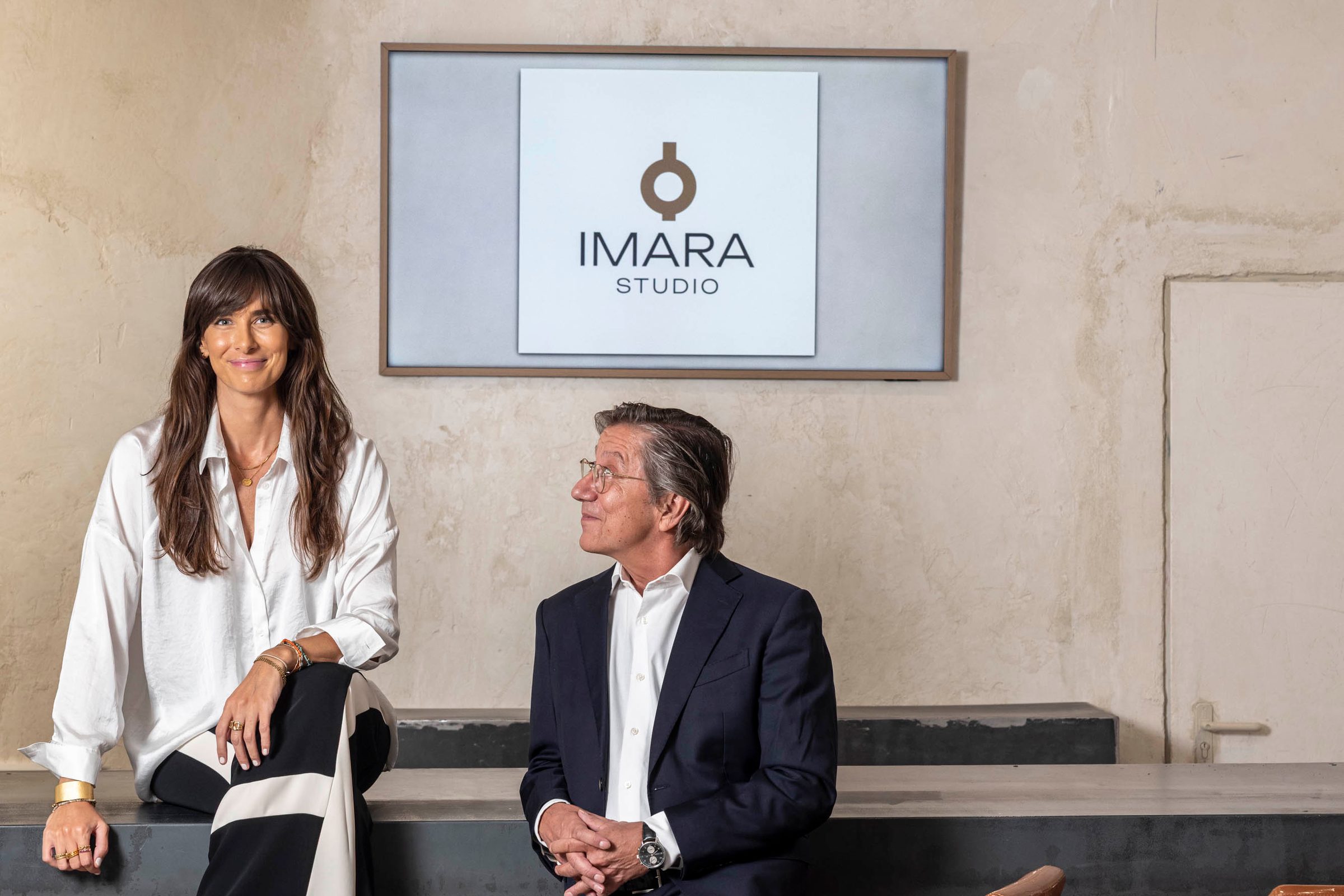Sandra Zobel y Pío Cabanillas en la barra de IMARA, bajo la pantalla con el logotipo de IMARA Studio