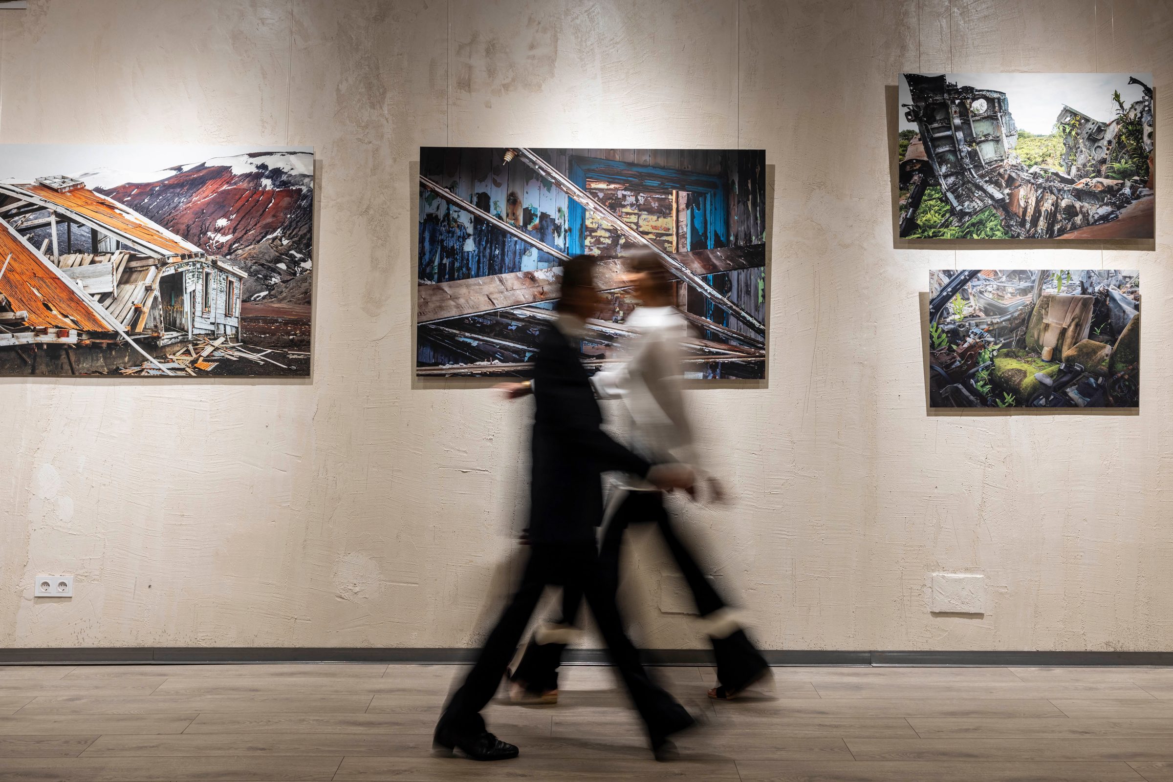 Sandra Zobel y Pío Cabanillas pasan caminando, en movimiento, ante las fotografías de la sala IMARA
